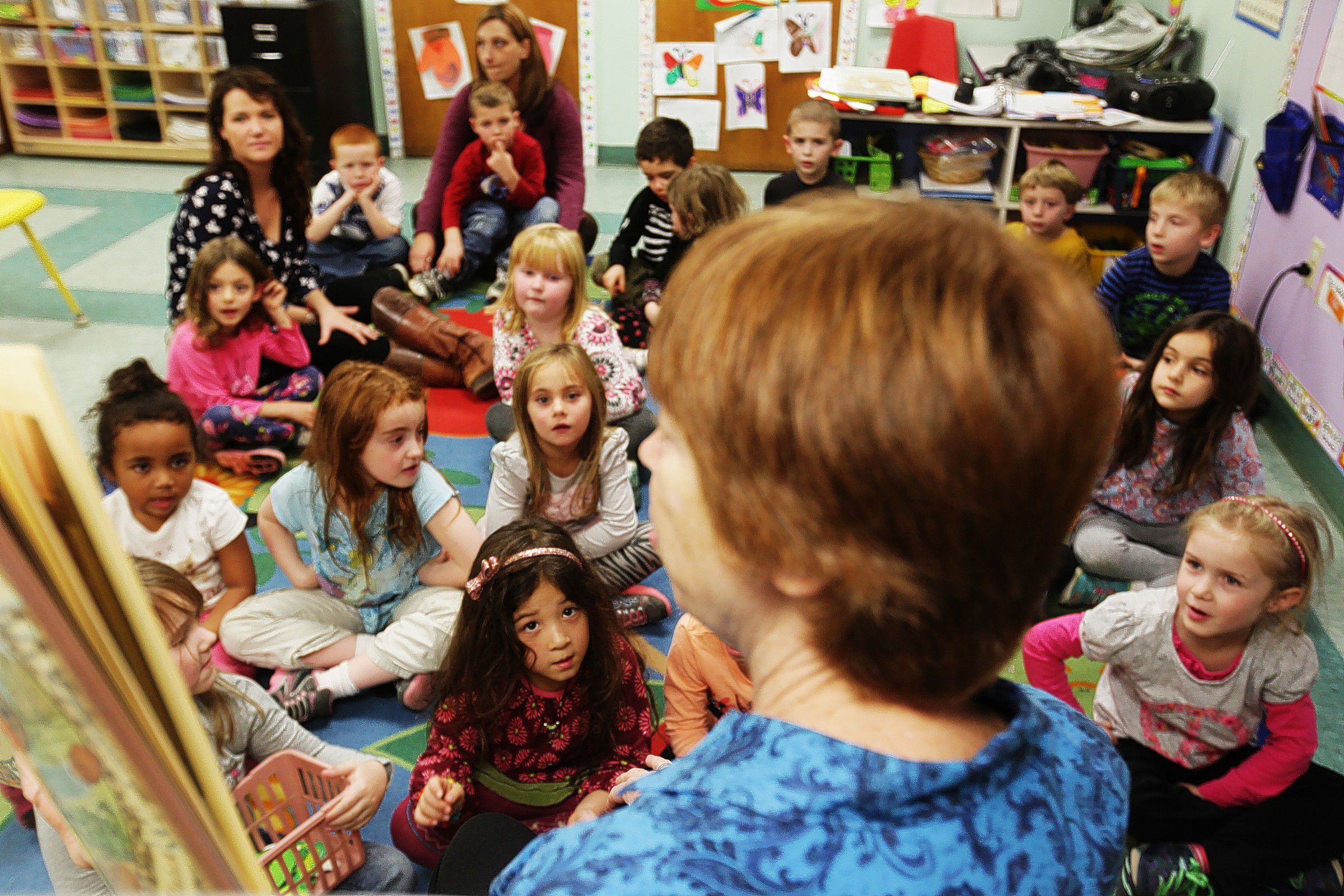 Volunteer reader Lynne West, center, reads to kids in the Penacook Community Center's pre-school on Thursday, December 5, 2013. The child care program at the PCC is currently at full capacity for the size of their facilities.   (ANDREA MORALES / Monitor staff) Volunteer reader Lynne West (center) reads to children in the Penacook Community Center’s preschool yesterday. The child-care program at the center is at full capacity for the size of its facilities.    Andrea Morales