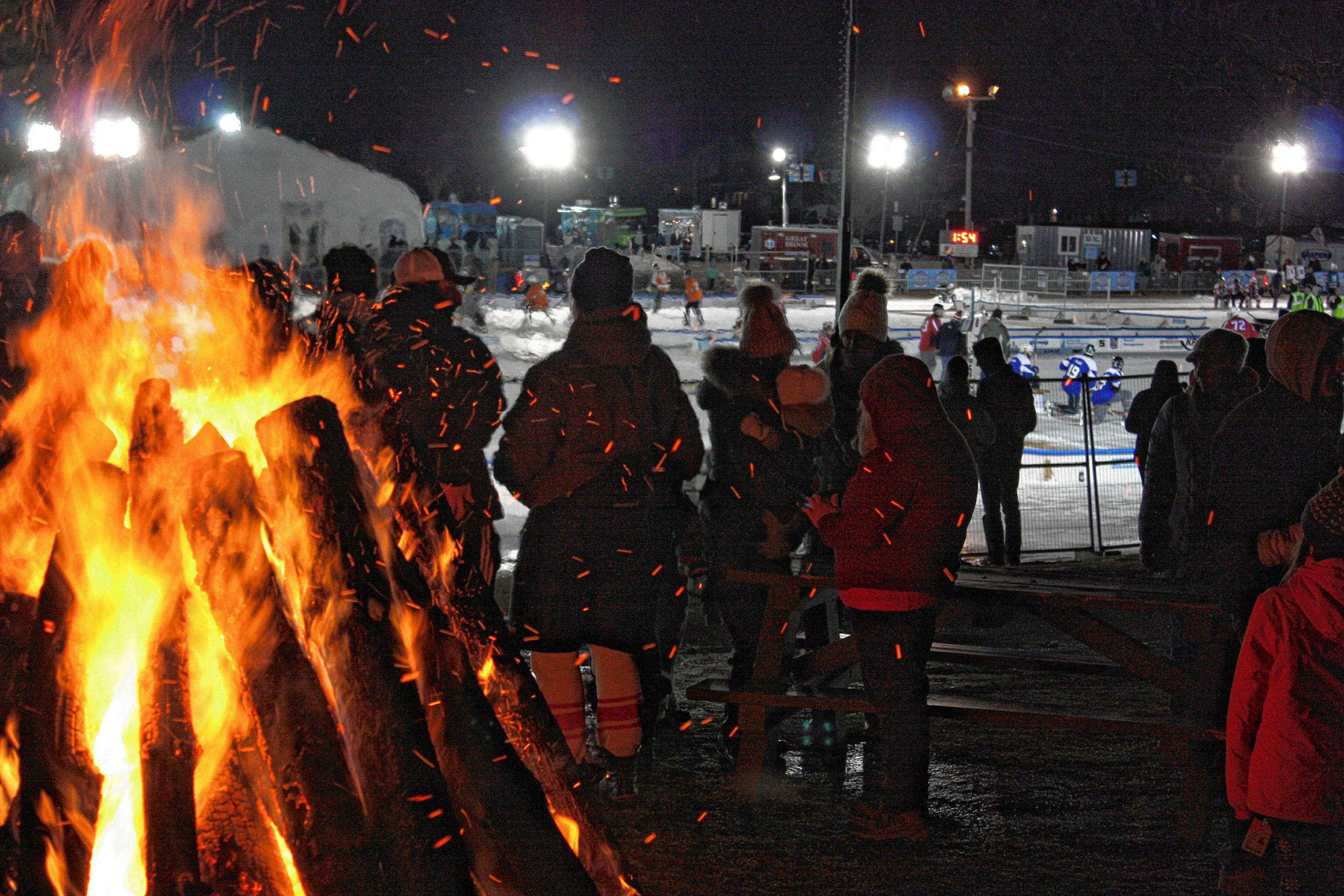 The massive bonfire was a very popular spot on this cold Saturday night of the 1883 Black Ice Pond Hockey Championship at White Park. 