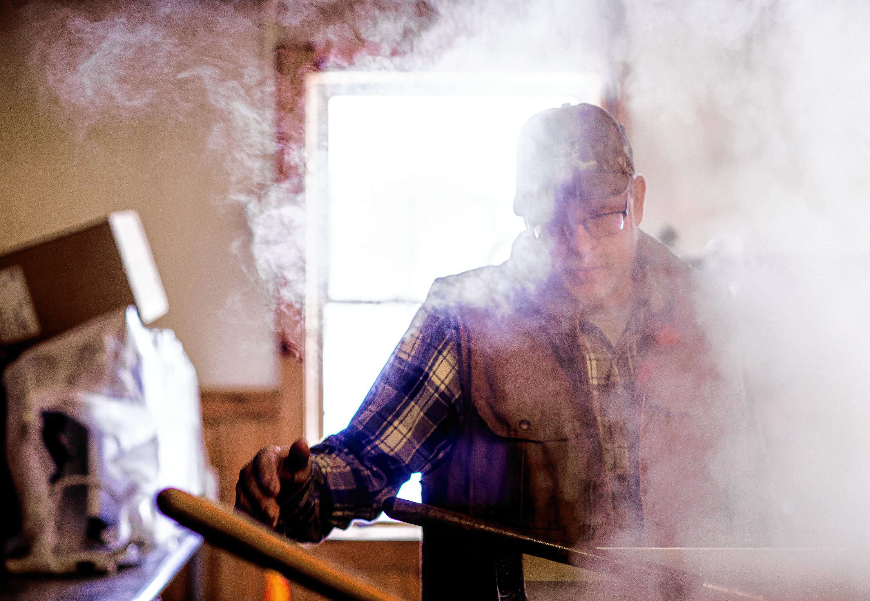 Larry Moore of  Windswept Maples Farm in Loudon stands at the envaporator to boil down the sap to make into syrup. GEOFF FORESTER