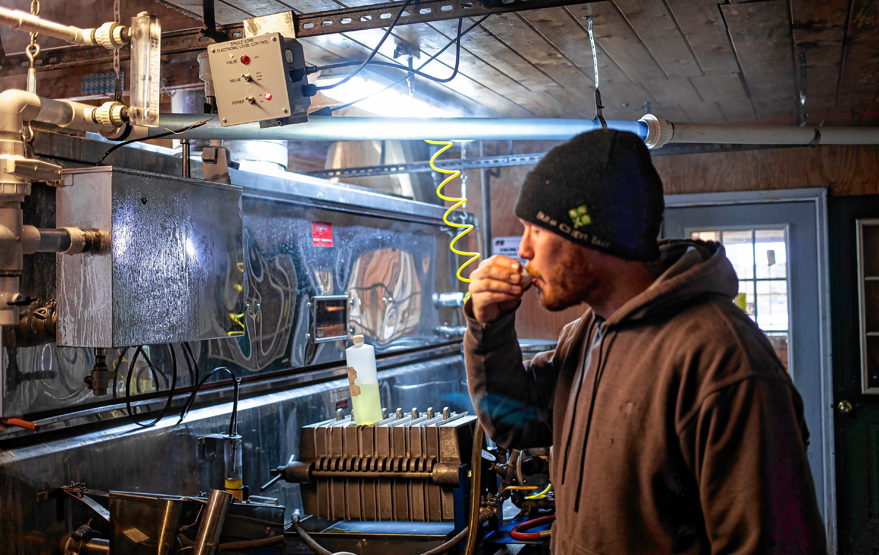 Jeff Moore tastes the final product as the evaporator makes syrup. GEOFF FORESTER