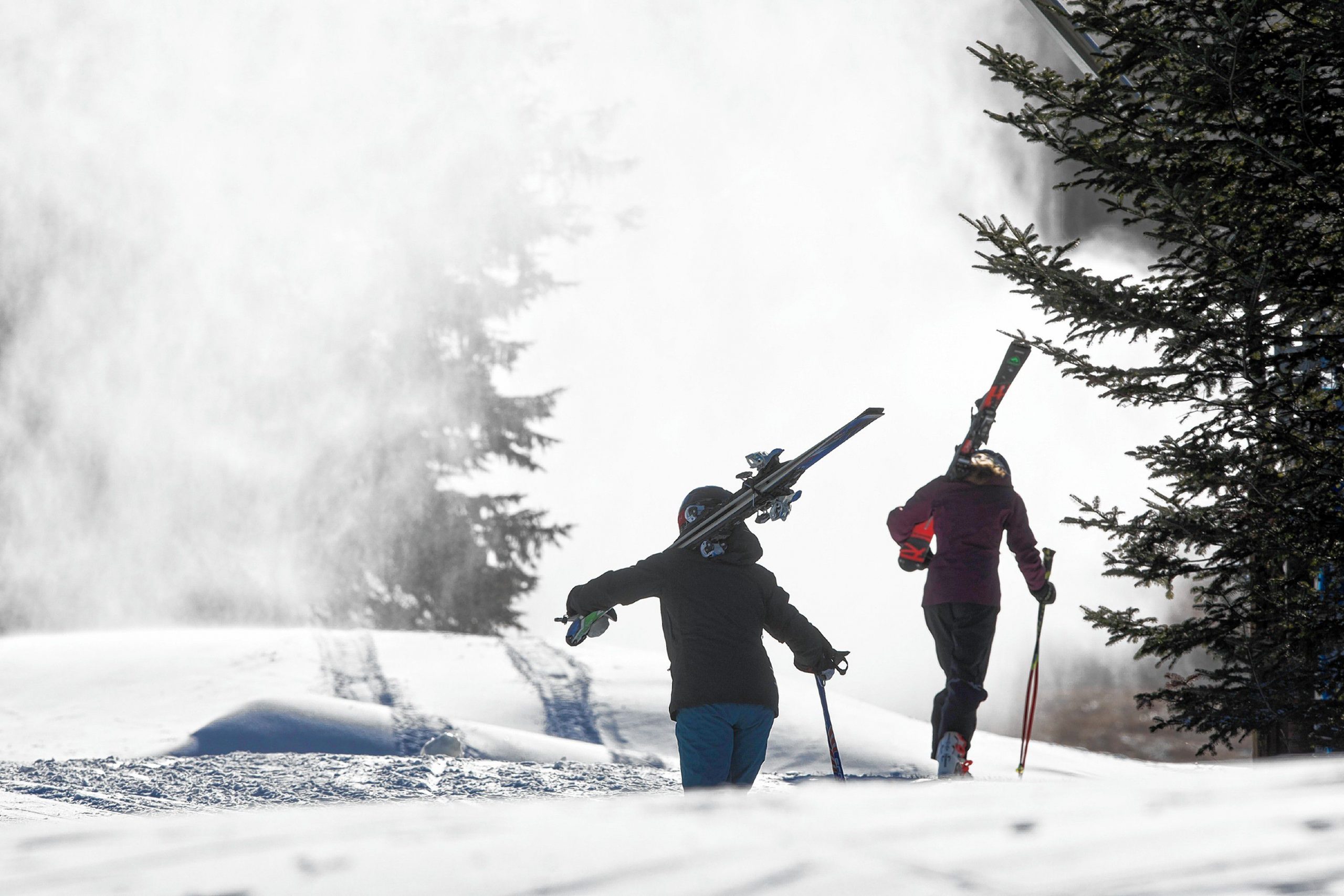 Skiers make their way up to the midway hut through the snow guns blowing snow at Pats Peak on Saturday, November 30, 2019.  