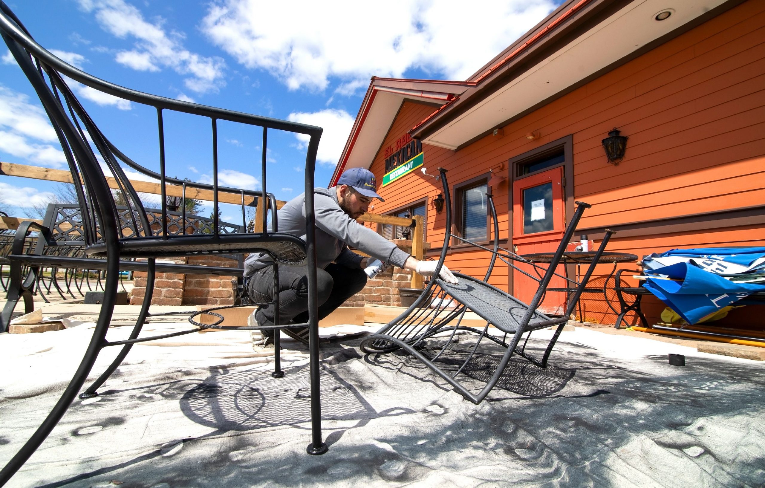 Jose Ramirez spray paints chairs in one of the two new patio areas on Tuesday, May 11, 2020 that El Rodeo Mexican Restaurant will be offering on May 18th as outdoor seating will be available. GEOFF FORESTER