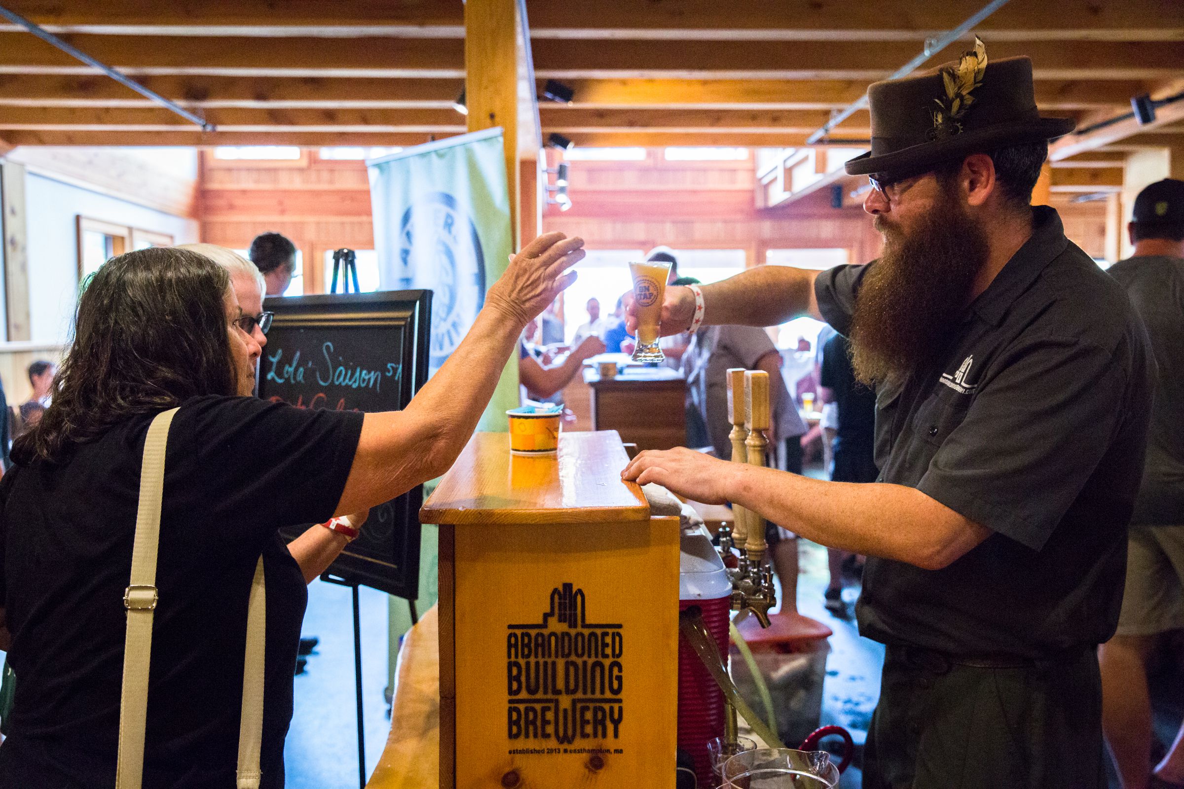 Paul Nichols, of Abandoned Building brewery in Easthampton, serves a beer to an attendee of Franklin County Beer Fest at Berkshire East in Charlemont Saturday, July 22, 2017. Recorder Staff/Matt Burkhartt