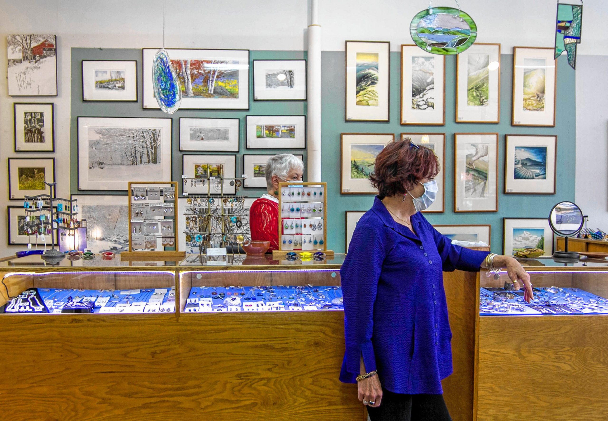 Employees Penny Verville (left) and Su Egan (right) talking to a customer inside of  the League of NH Craftsman located in Downtown Concord on Main Street October 1st, 2020. ALLIE ST PETER