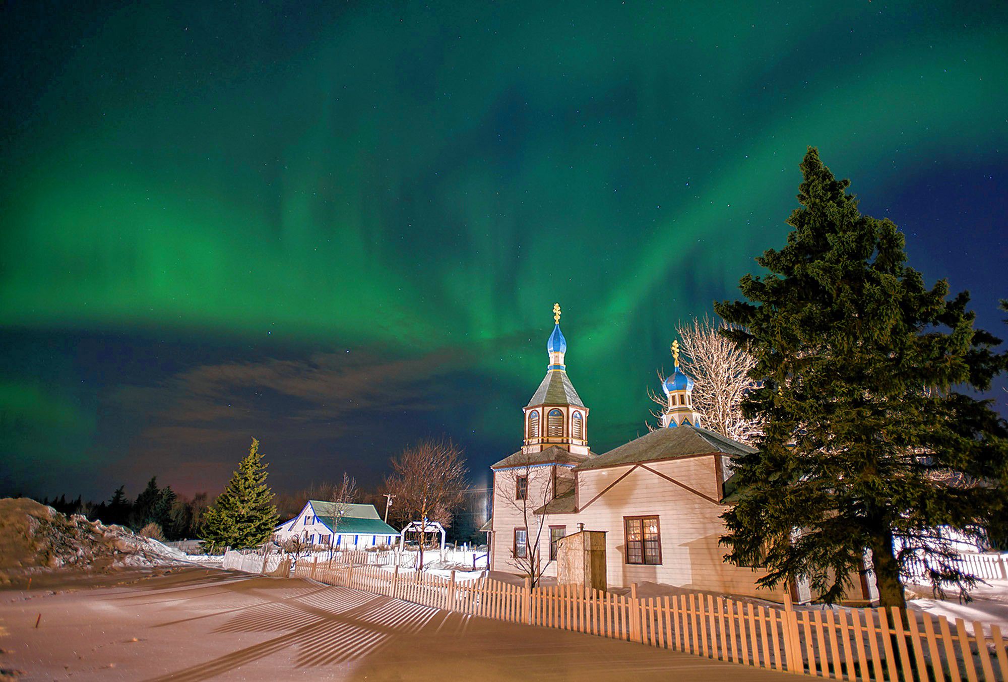 FILE - In this March 17, 2013, file photo, the aurora borealis, or northern lights, fill the night sky above the Holy Assumption of the Virgin Mary Russian Orthodox church in Kenai, Alaska. The phenomenon occurs when electrically charged particles from the sun enter the earth's atmosphere. Robert Rutledge, of the U.S. government's space weather prediction center said Thursday, Dec. 10, 2020, that stargazers in the continental 48 states have very little chance of seeing the northern lights this week despite an initial promising forecast. (AP Photo/M. Scott Moon, File) M. SCOTT MOON