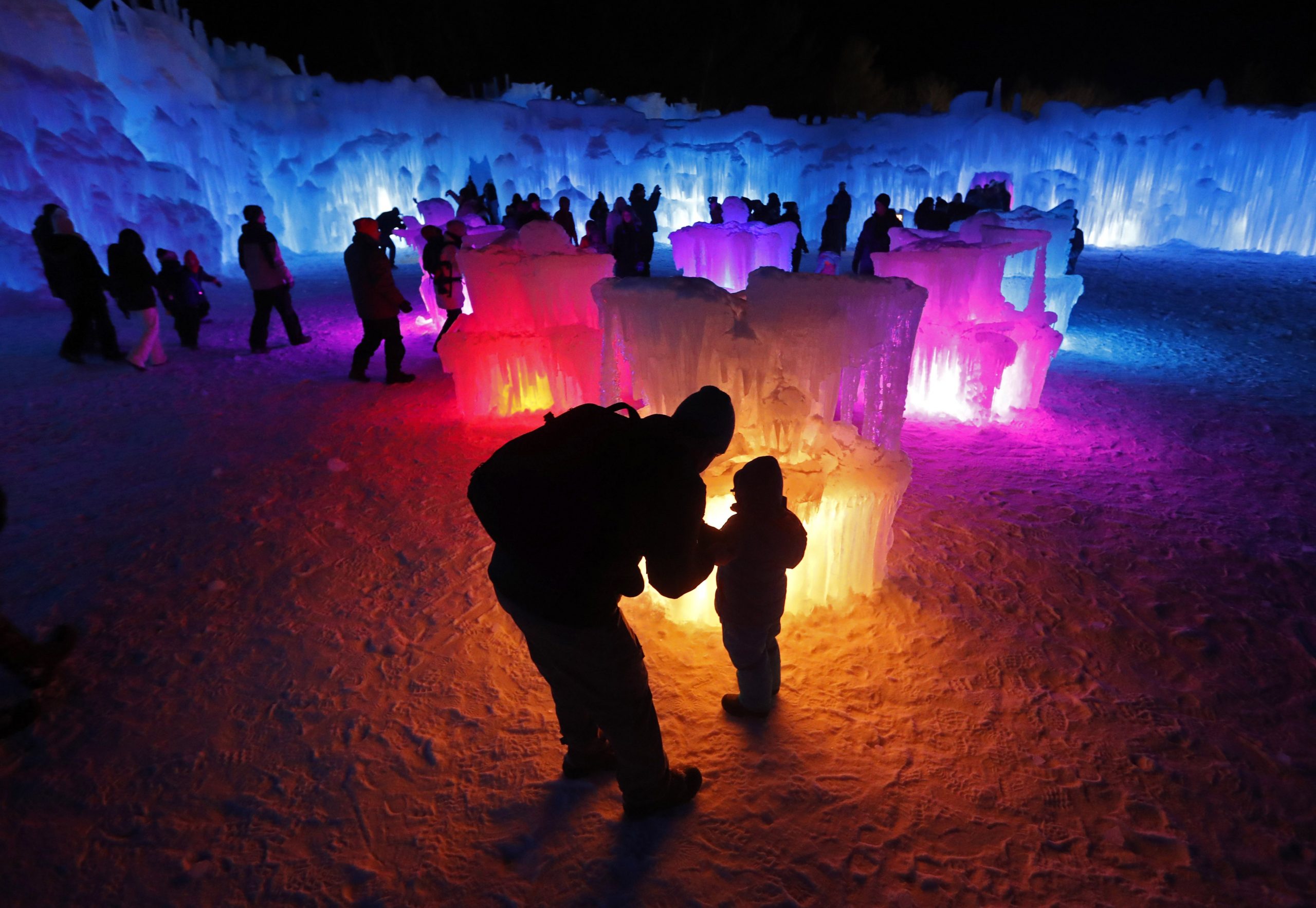 In this Saturday, Jan. 26, 2019 photo, Bruce McCafferty and his son, Dougie, pause while exploring the ice formations growing at Ice Castles in North Woodstock, N.H. (AP Photo/Robert F. Bukaty)  Robert F. Bukaty