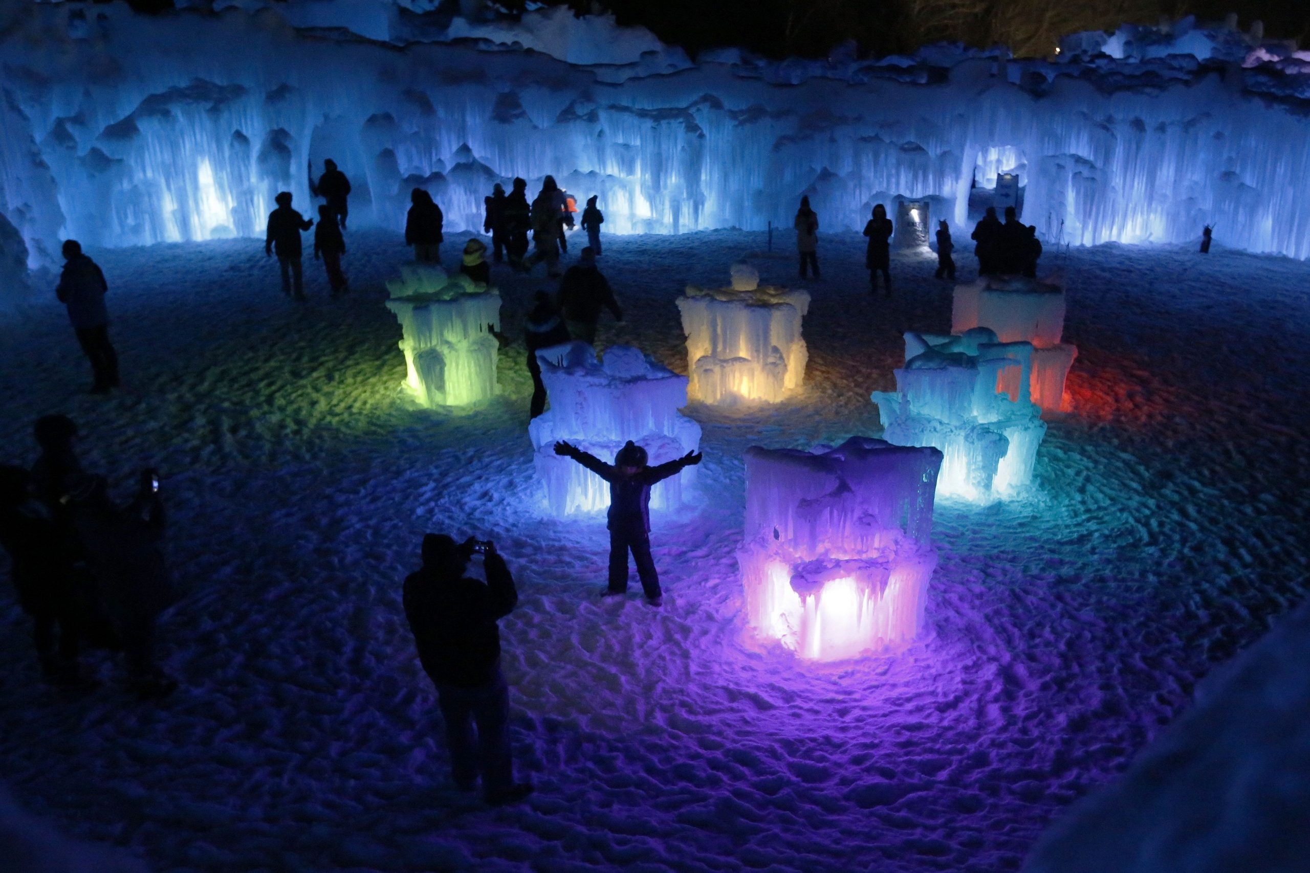 FILE - In this Jan. 25, 2019 file photo, a youngster poses near ice formations in the courtyard at Ice Castles in North Woodstock, N.H. Organizers of annual hand-crafted sculptures said the popular attraction will open as planned on Friday, Jan. 10, 2020, despite the warmer weather expected through the weekend. (AP Photo/Robert F. Bukaty, File)  Robert F. Bukaty