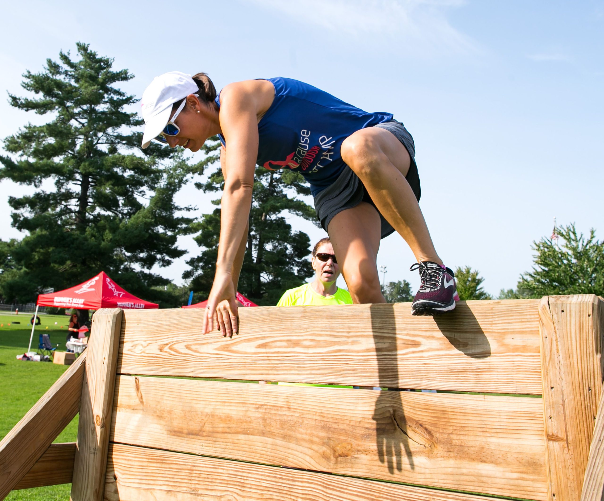 Renee Plodzik jumps over the obstacle wall at the boot camp she runs each Sunday through the summer at Memorial Field on August 19, 2018.  