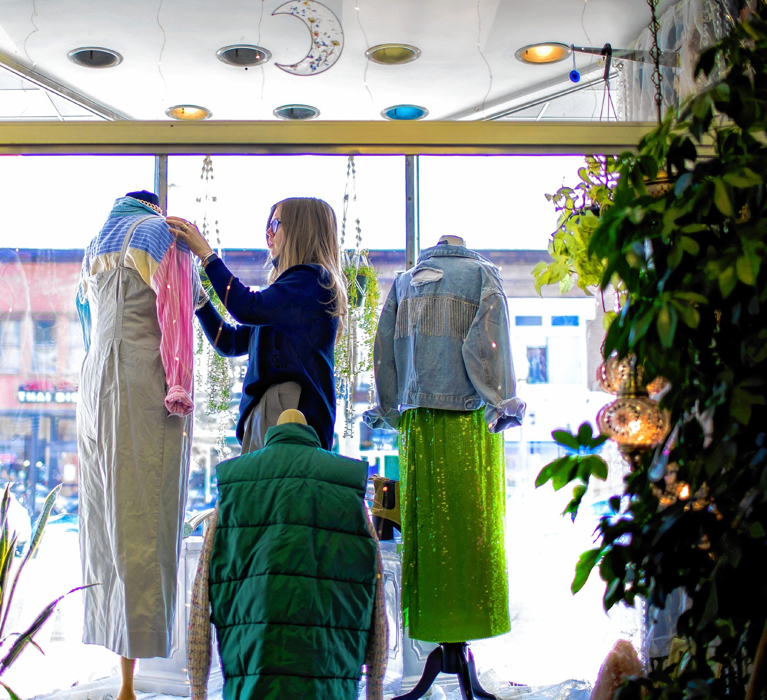 Elyssa Alferi, the owner of Lilise Designer Resale, a vintage and designer consignment store on Main Street works on the clothing in the front window. GEOFF FORESTER