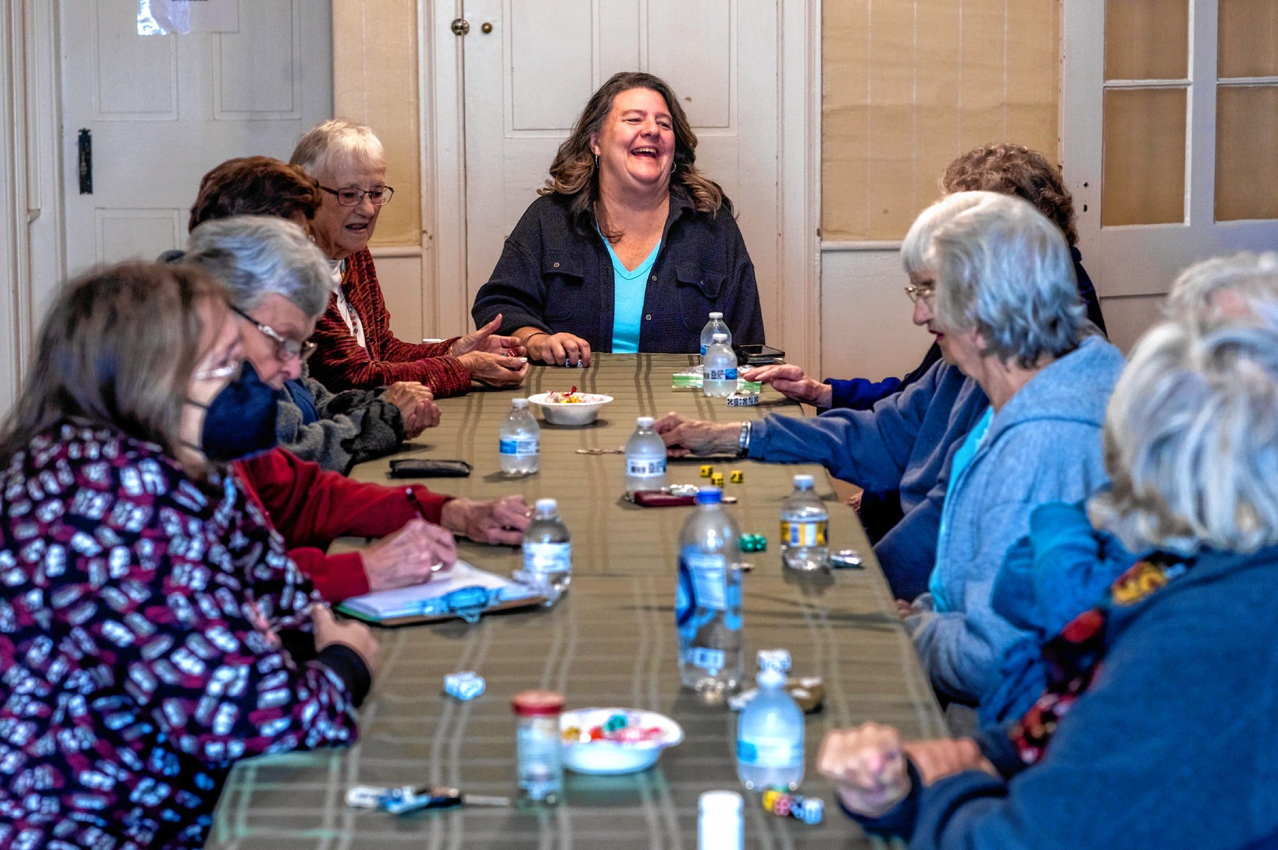 Former intergenerational outreach coordinator Kristen Pinard-Kenney (center) laughs with the women from the Senior Center that have known each other for over 20 years as they play a dice game at the Penacook Historical Society on Thursday, November 1, 2023. GEOFF FORESTER